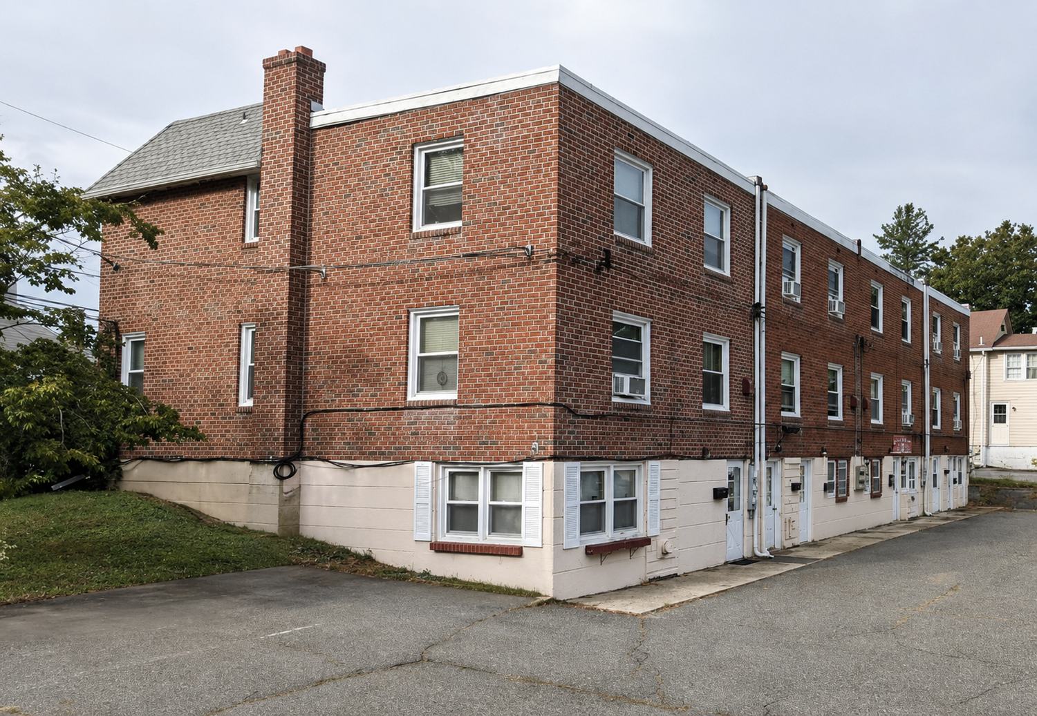 The JHL Irrigation & Sprinklers office — a three-story red brick building with white-trimmed windows at 12 Smedley Ln, Newtown Square, PA.